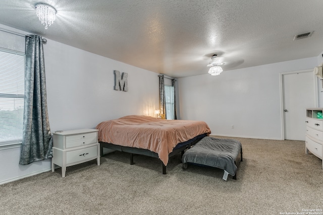 bedroom featuring light carpet, a textured ceiling, and ceiling fan