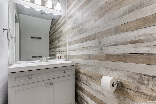 bathroom with vanity and wood walls