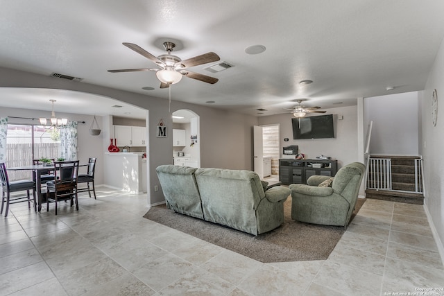 living room featuring ceiling fan with notable chandelier