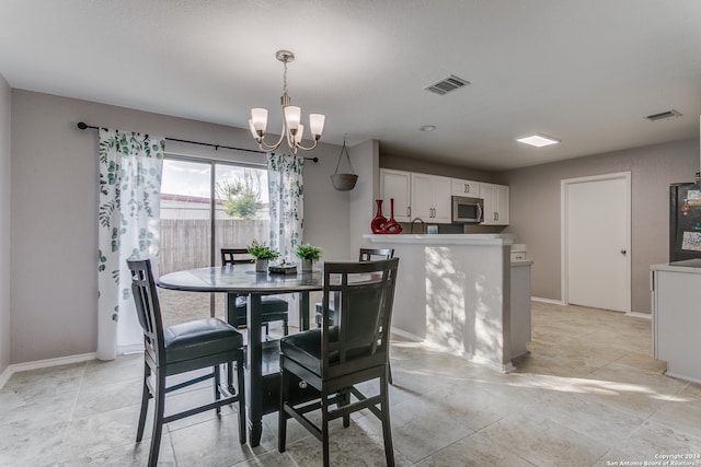 dining room featuring sink and a chandelier