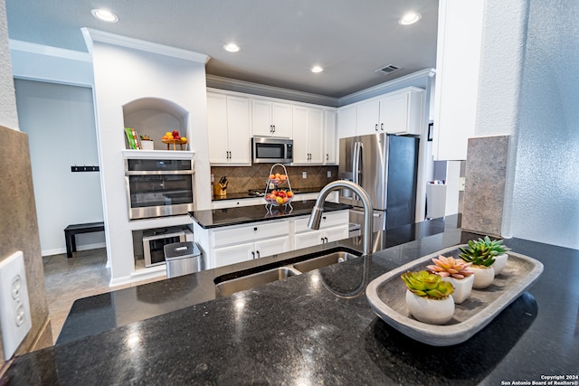 kitchen featuring white cabinets, appliances with stainless steel finishes, tasteful backsplash, and sink