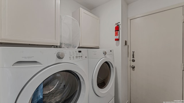 clothes washing area with cabinets and washer and clothes dryer