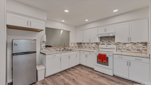 kitchen with sink, electric range, white cabinets, stainless steel refrigerator, and light hardwood / wood-style flooring