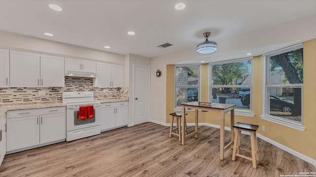 kitchen featuring light hardwood / wood-style flooring, white cabinets, and electric stove