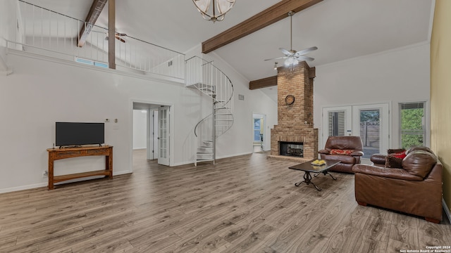 living room featuring light wood-type flooring, a brick fireplace, ceiling fan, beam ceiling, and high vaulted ceiling