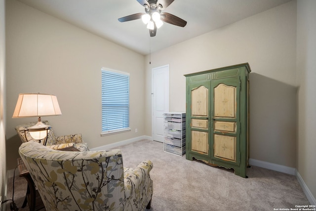 living area featuring light carpet and ceiling fan