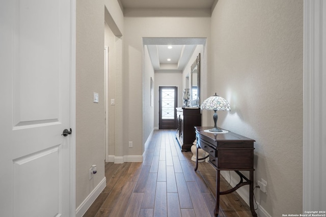 doorway to outside with dark hardwood / wood-style floors and a raised ceiling