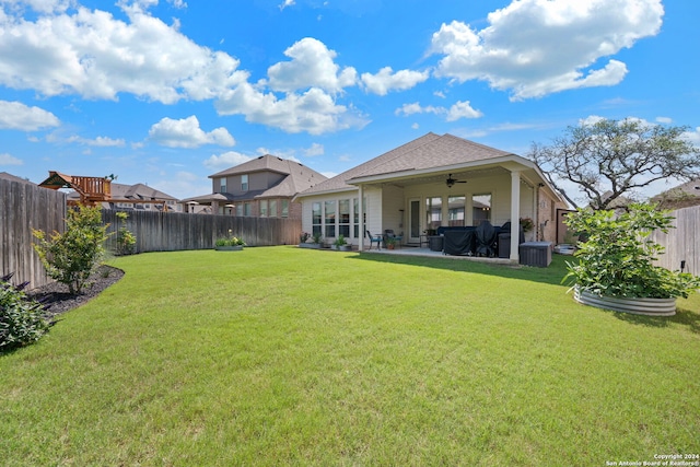 rear view of house with a patio, ceiling fan, and a lawn