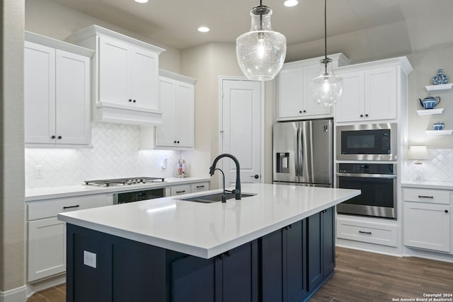 kitchen featuring decorative backsplash, appliances with stainless steel finishes, sink, white cabinets, and hanging light fixtures