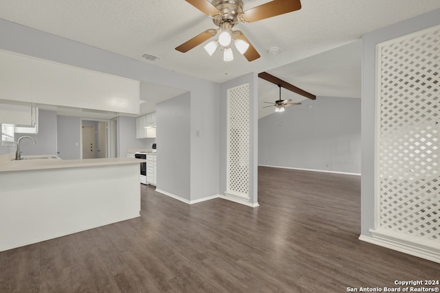 unfurnished living room featuring vaulted ceiling with beams, sink, dark hardwood / wood-style flooring, a textured ceiling, and ceiling fan