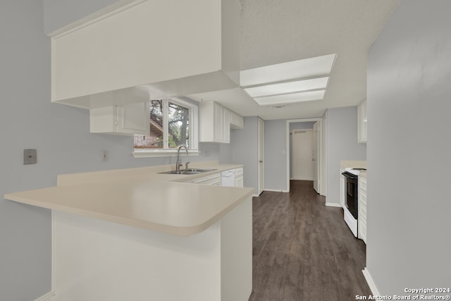 kitchen with dark wood-type flooring, kitchen peninsula, sink, white cabinets, and white appliances