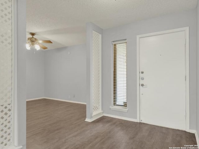 foyer featuring a textured ceiling, dark hardwood / wood-style floors, and ceiling fan