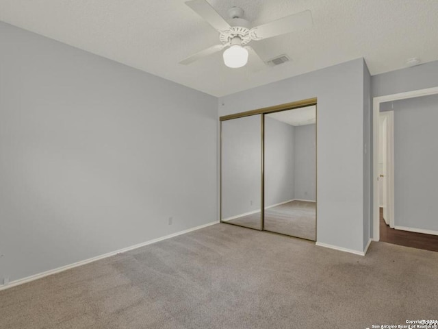 unfurnished bedroom with light colored carpet, a closet, and ceiling fan