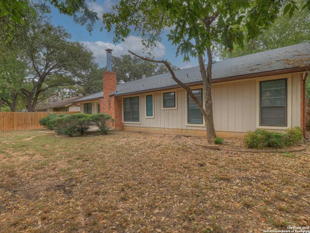 rear view of house featuring a lawn