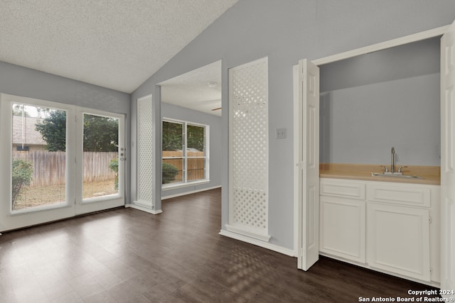 interior space with sink, a textured ceiling, ceiling fan, lofted ceiling, and hardwood / wood-style flooring