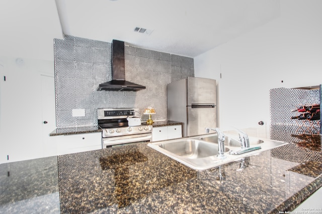 kitchen featuring appliances with stainless steel finishes, sink, white cabinets, dark stone countertops, and extractor fan