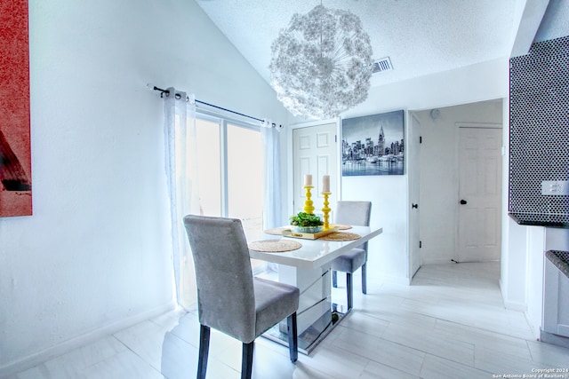 dining area with a textured ceiling and vaulted ceiling