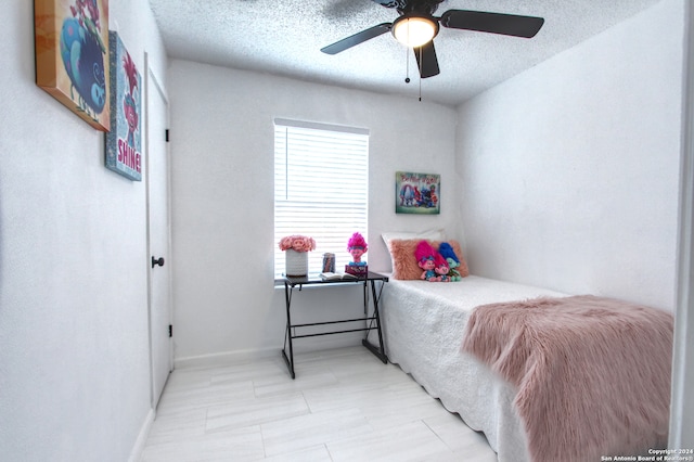 bedroom featuring ceiling fan and a textured ceiling