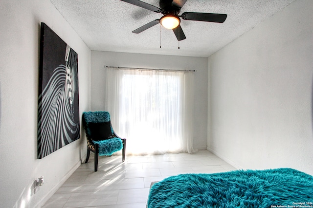 tiled bedroom featuring a textured ceiling and ceiling fan