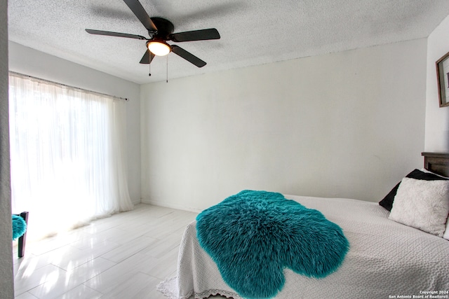 bedroom with a textured ceiling and ceiling fan