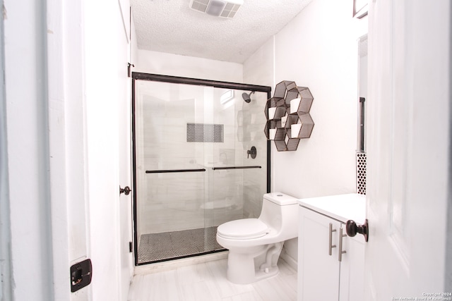 bathroom with vanity, toilet, walk in shower, and a textured ceiling