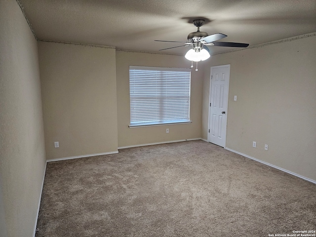 carpeted spare room with a textured ceiling and ceiling fan