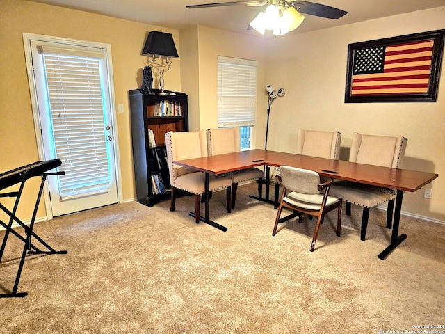 carpeted dining space with ceiling fan