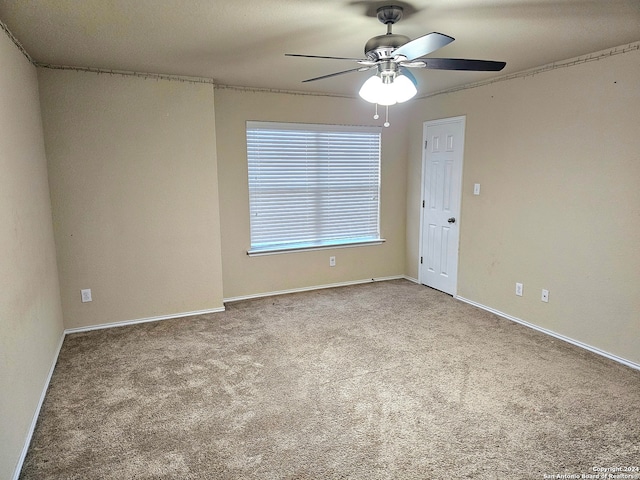 carpeted spare room featuring ceiling fan