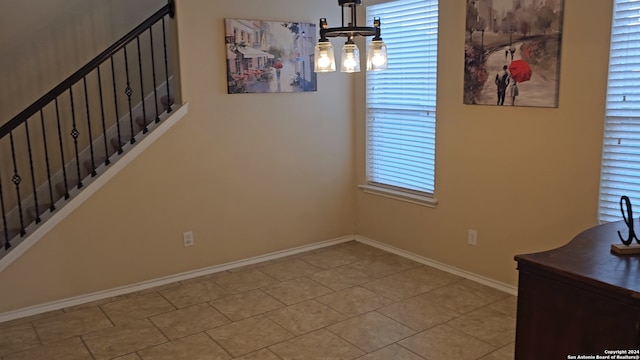 unfurnished dining area featuring a notable chandelier and light tile patterned floors