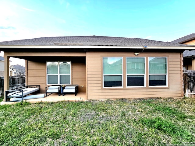 rear view of property with a patio, an outdoor living space, and a lawn