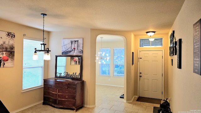 foyer featuring a textured ceiling and light tile patterned floors