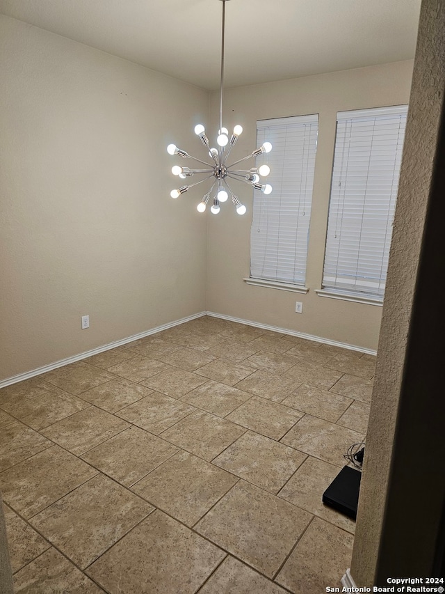 spare room featuring a notable chandelier