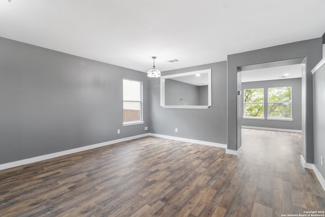 unfurnished room featuring dark hardwood / wood-style floors and plenty of natural light