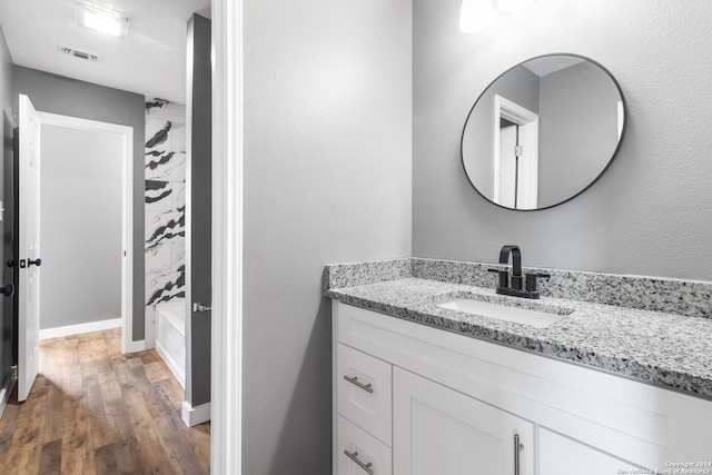 bathroom with vanity, washtub / shower combination, and wood-type flooring