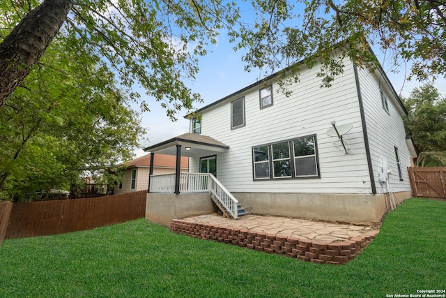 rear view of property featuring a patio area and a lawn