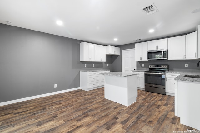 kitchen with a center island, appliances with stainless steel finishes, dark hardwood / wood-style floors, and white cabinetry