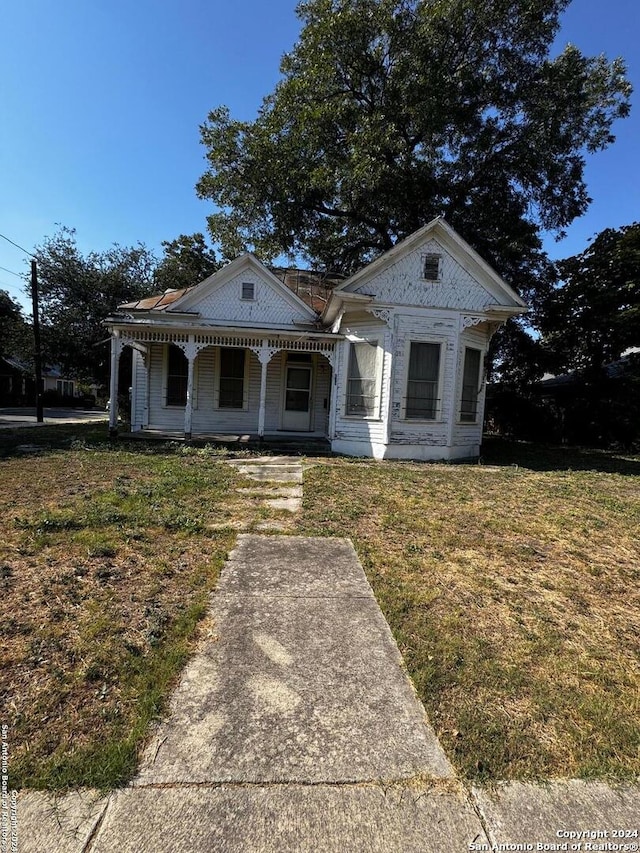 neoclassical home with covered porch and a front yard