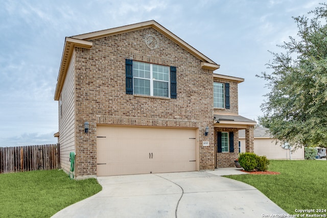 view of property featuring a garage and a front lawn