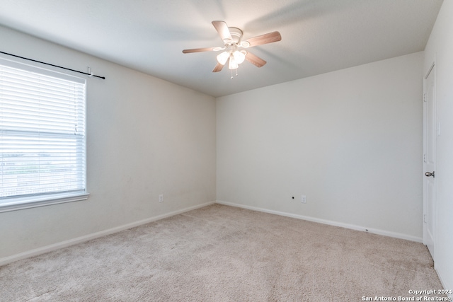 empty room featuring light colored carpet and ceiling fan