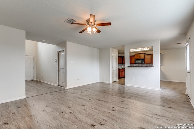 unfurnished living room featuring light hardwood / wood-style flooring and ceiling fan