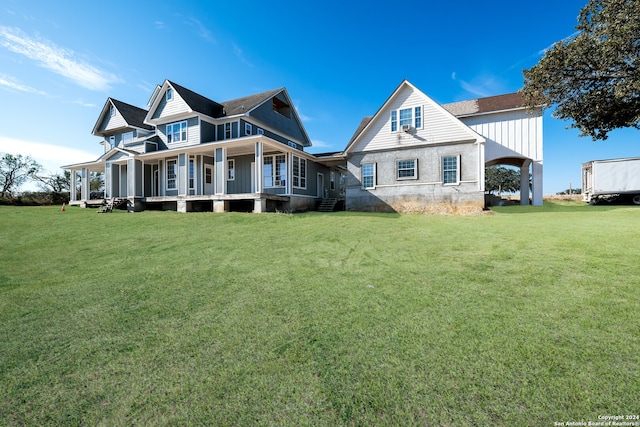 rear view of property featuring a porch and a lawn