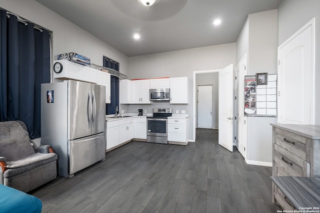 kitchen with dark wood-type flooring, stainless steel appliances, and white cabinets