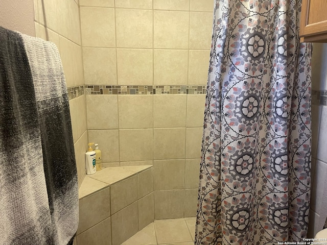 bathroom with a shower with shower curtain and tile patterned flooring