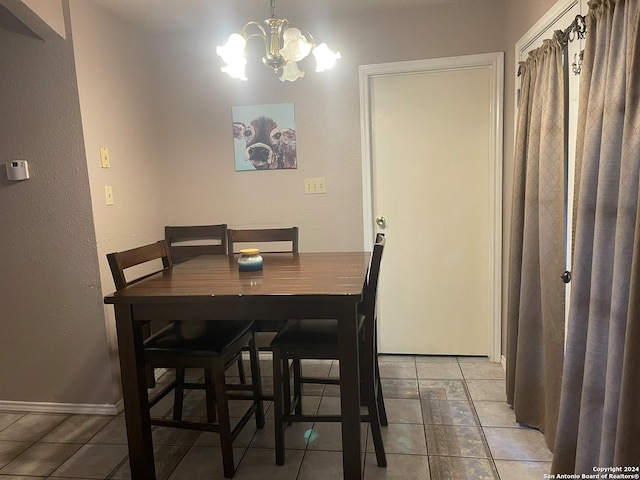 tiled dining room with a chandelier