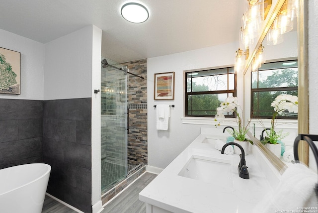 bathroom featuring vanity, wood-type flooring, and separate shower and tub