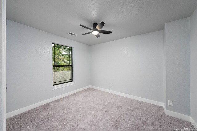 carpeted empty room with a textured ceiling and ceiling fan