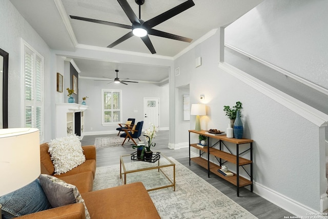 living room with crown molding, wood-type flooring, and ceiling fan