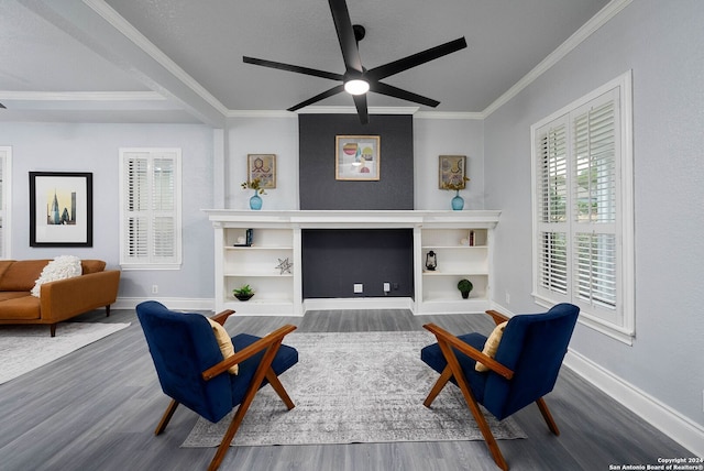 sitting room with crown molding, dark wood-type flooring, and ceiling fan