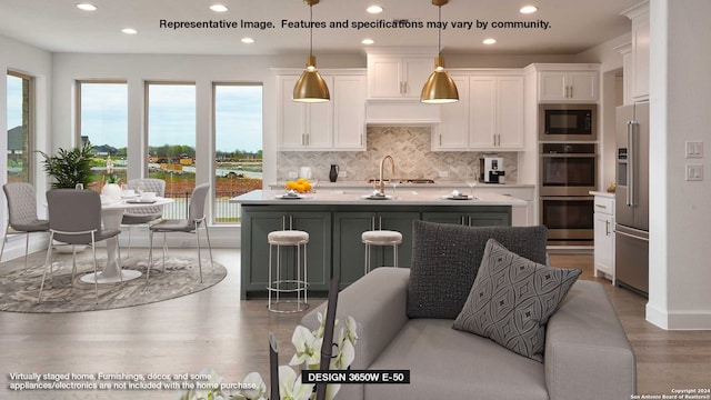 kitchen with stainless steel appliances, backsplash, white cabinets, and light countertops