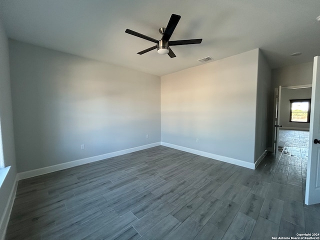 empty room featuring ceiling fan and dark hardwood / wood-style flooring